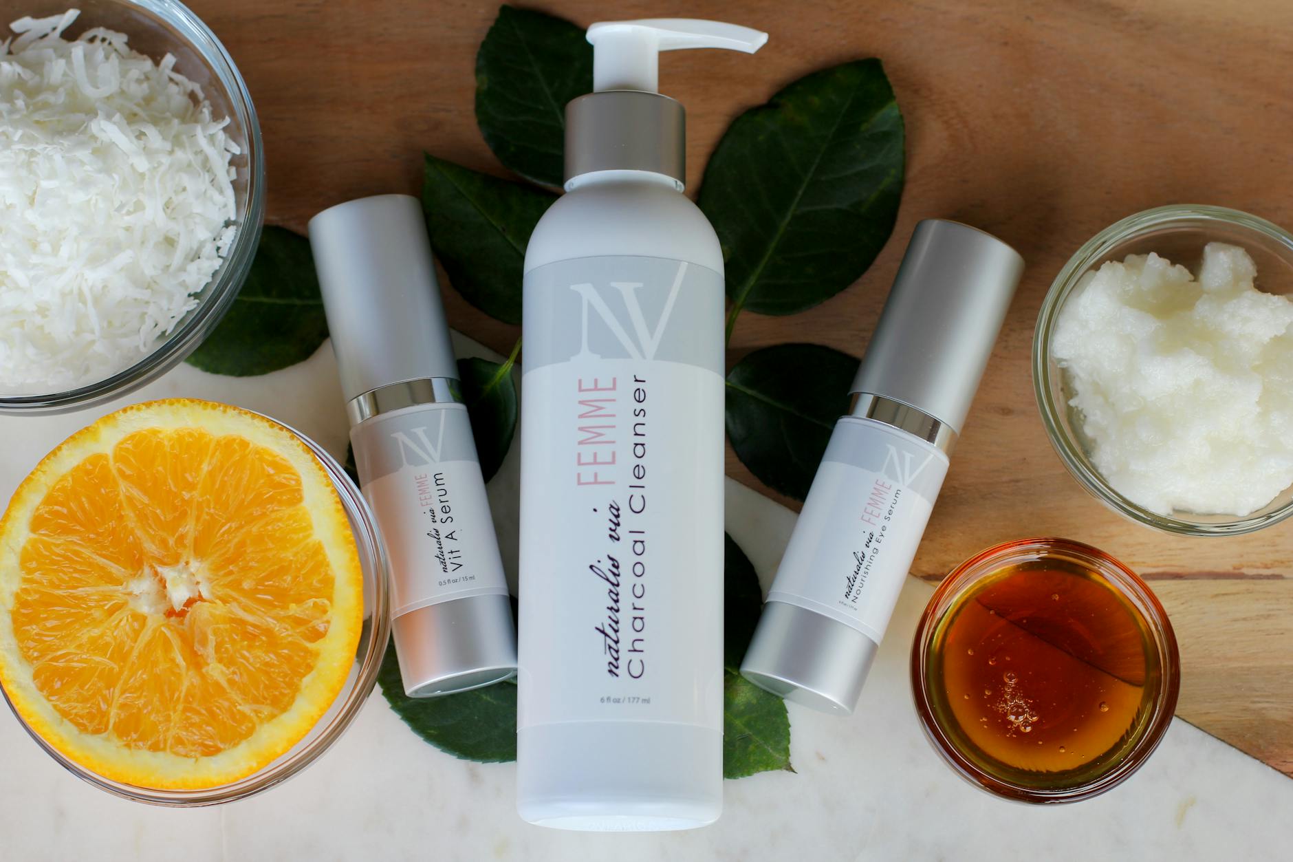 Naturalne kosmetyki z kokosem, pomarańczą i miodem na tle stołu