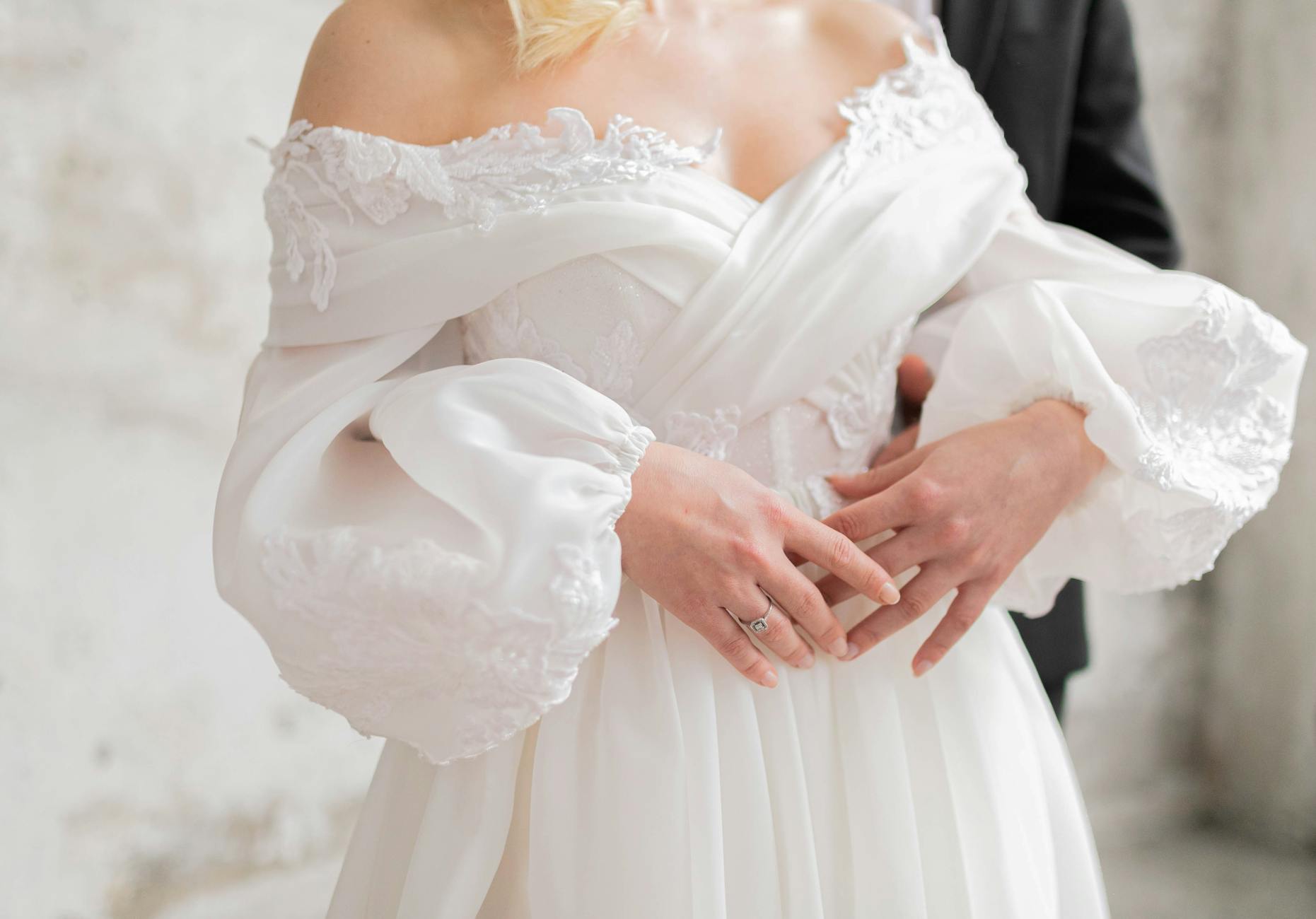 Para młoda w eleganckim uścisku, panna młoda w nowoczesnej sukni ślubnej