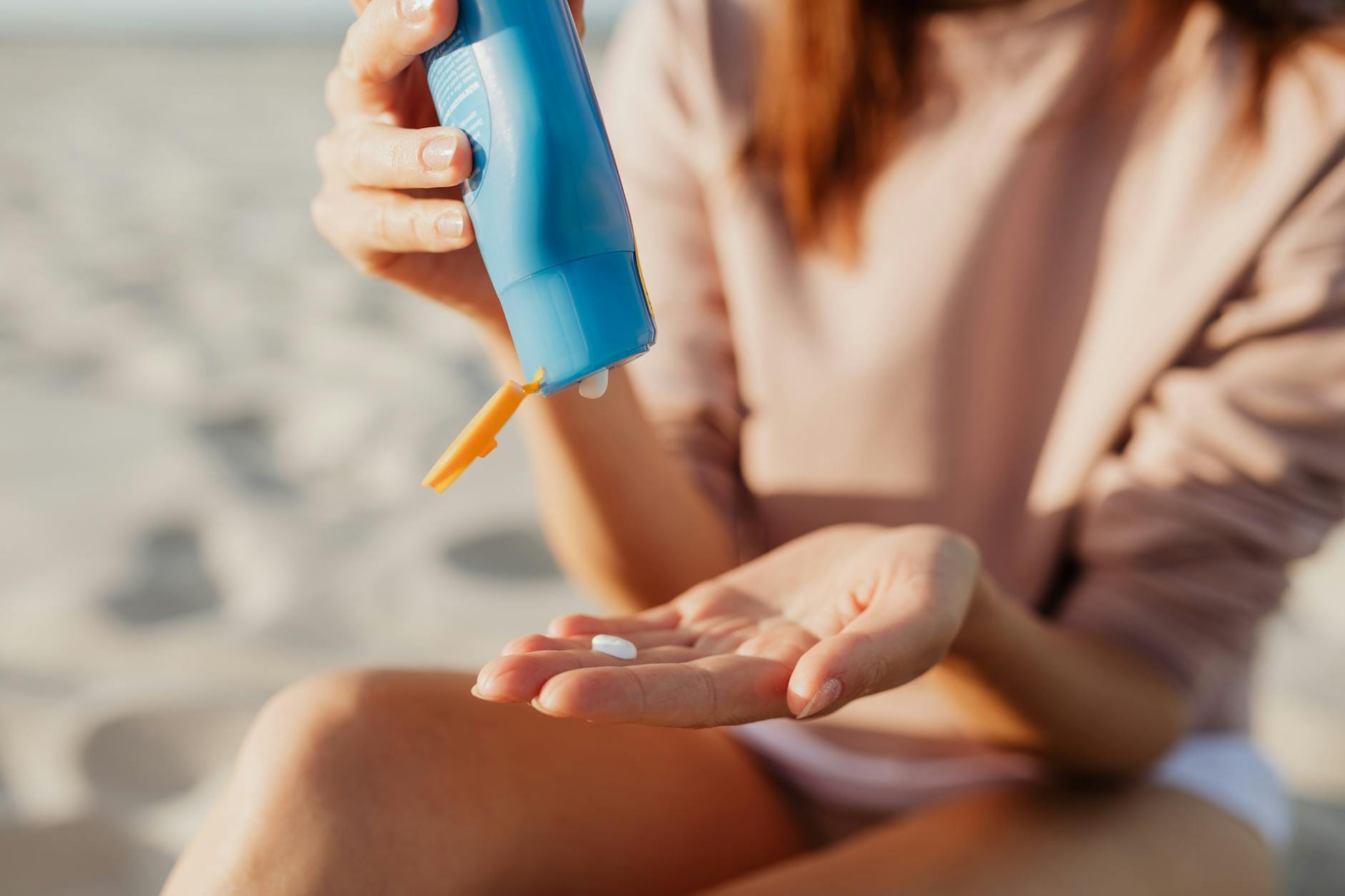 Czy filtr SPF działa, jeśli nałożysz go za mało? Co mówi praktyka i badania Osoba nakłada krem z filtrem na plaży w słoneczny dzień