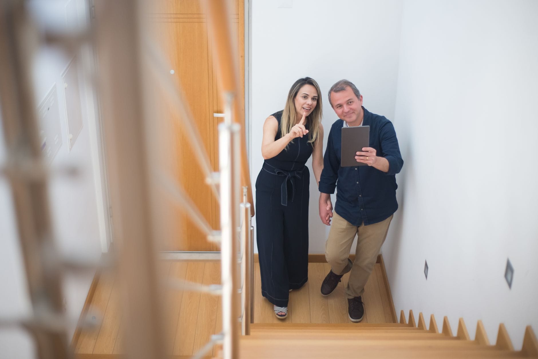 Para robi selfie na drewnianych schodach w nowym mieszkaniu